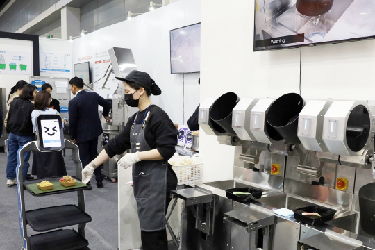 사진은 조리자동 로봇인 오토웍이 만든 음식을 서빙로봇에 담고 있는 모습. 삼성웰스토리 제공